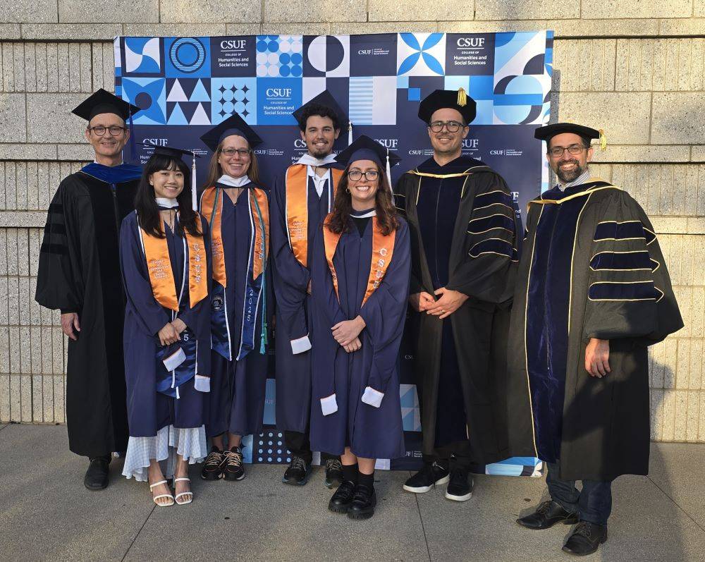 Graduate student posing next to faculty