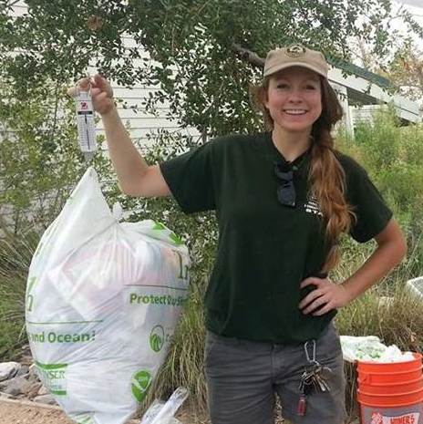 Veronica Roach smiling, holding a trash bag